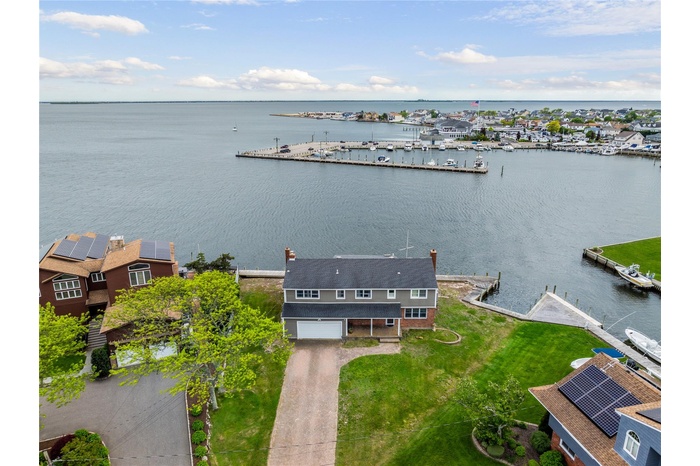 Aerial view of property and surrounding area featuring a large body of water