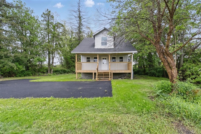 View of front of property featuring a porch and a front lawn