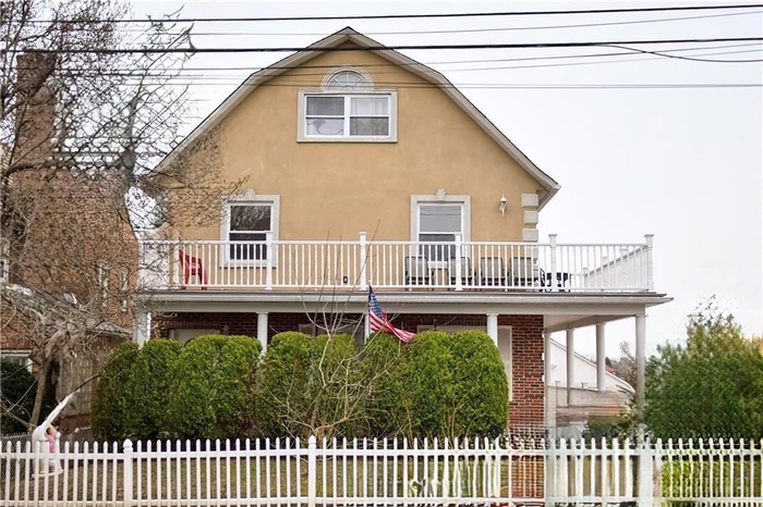 View of front facade featuring a balcony and stucco siding