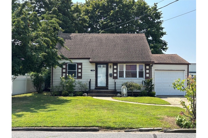 View of front facade with an attached garage, a shingled roof, and driveway