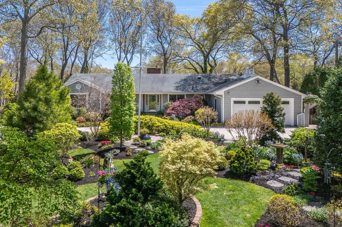 View of front of property featuring an attached garage and roof with shingles
