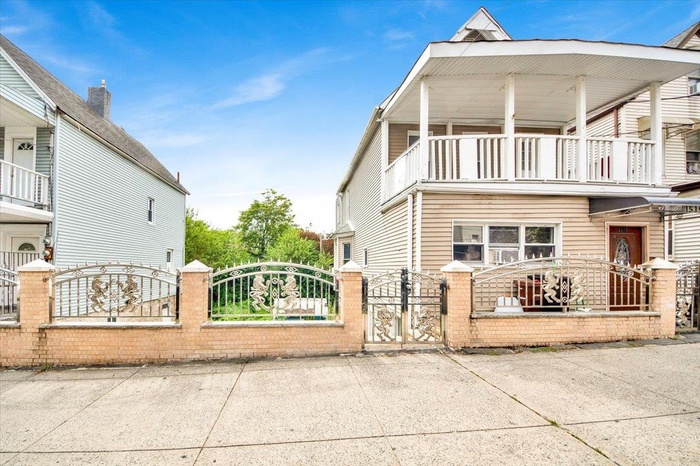 View of home's exterior with a balcony, a gate, and a fenced front yard