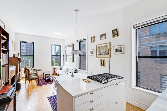 Kitchen featuring light wood-style floors, white cabinetry, modern cabinets, and hanging light fixtures