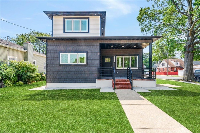 View of front of house featuring covered porch and a front yard
