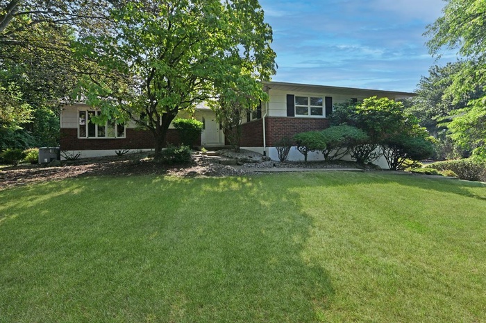 Single story home with brick siding and a front yard