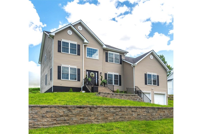 View of front of home featuring a front yard and an attached garage