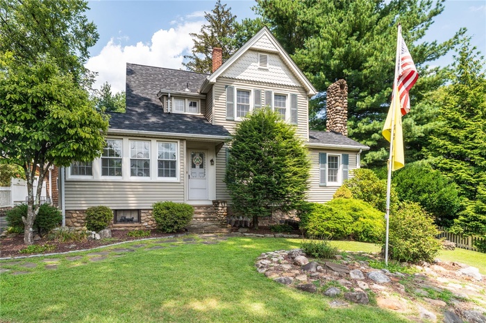 Victorian home featuring a chimney, a shingled roof, and entry steps