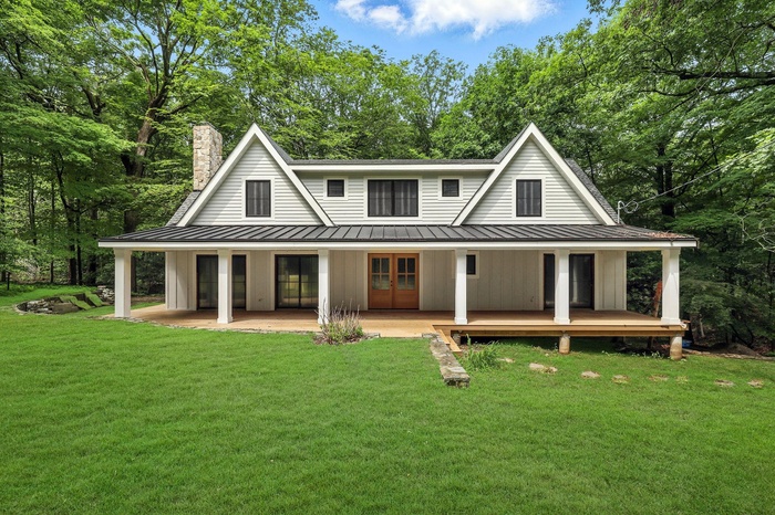 View of front of house featuring a standing seam roof, a metal roof, and french doors