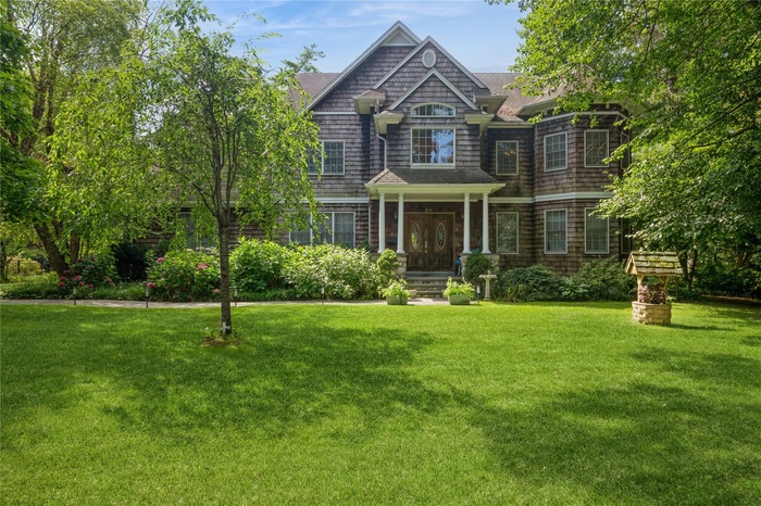 Shingle-style home with a front yard
