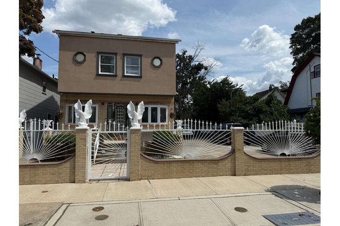 View of front of property featuring a fenced front yard, stucco siding, brick siding, covered porch, and a gate