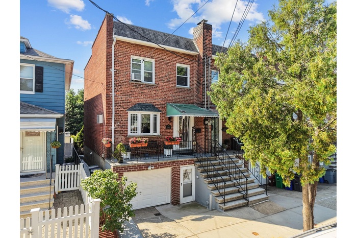 Traditional-style home with brick siding, driveway, an attached garage, and a chimney