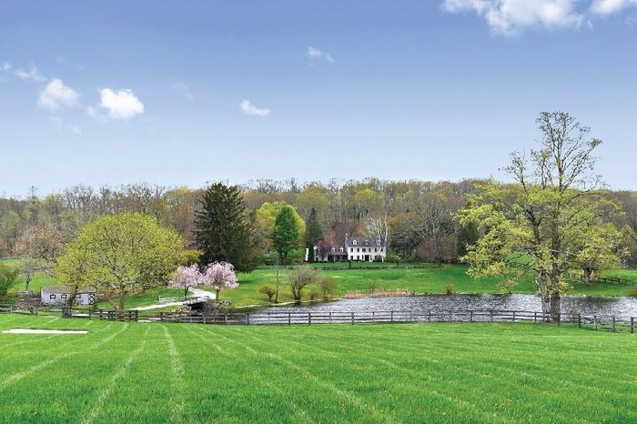 View of property's community with fence, a water view, and a yard