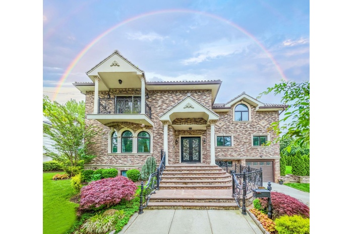 View of front of home featuring a balcony, concrete driveway, french doors, an attached garage, and brick siding