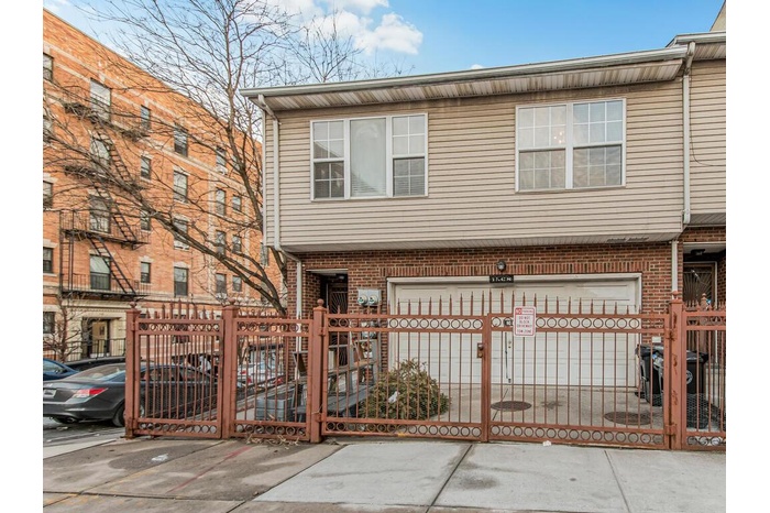 View of property featuring a fenced front yard, a gate, and brick siding