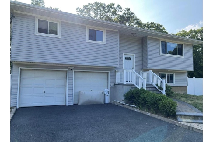 Split foyer home with an attached garage and driveway