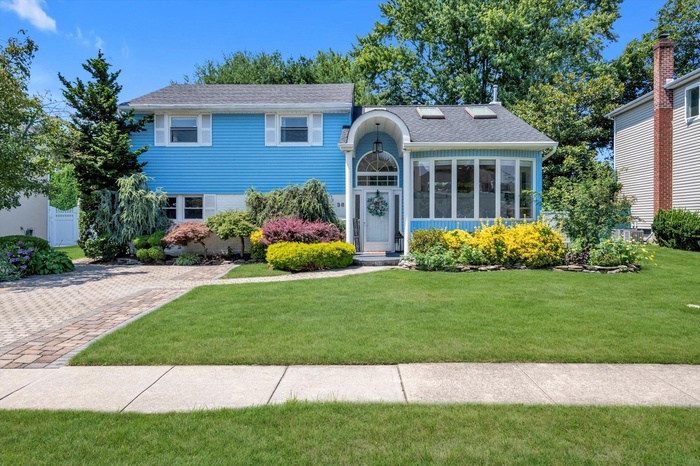 View of front of house featuring a front lawn and roof with shingles
