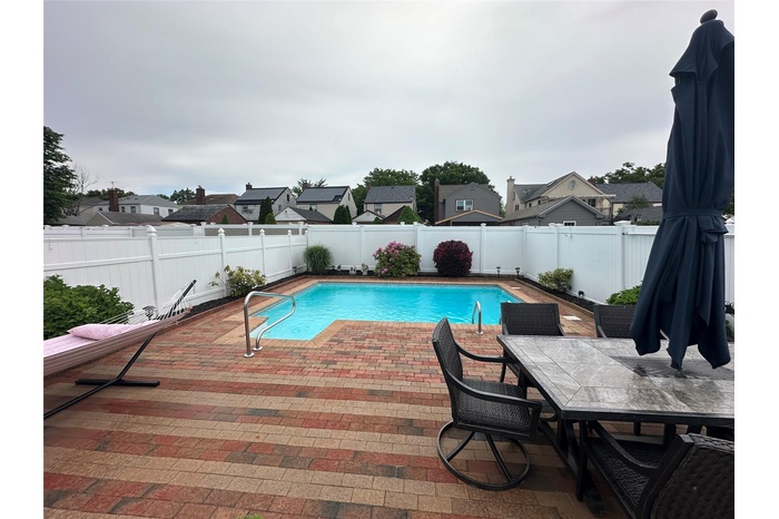 View of pool featuring a fenced backyard, a residential view, and a patio area