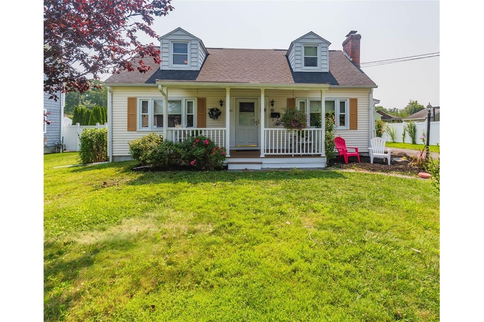 Cape cod-style house with a porch, a chimney, and a shingled roof