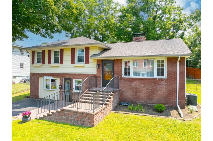 Tri-level home with a chimney and brick siding