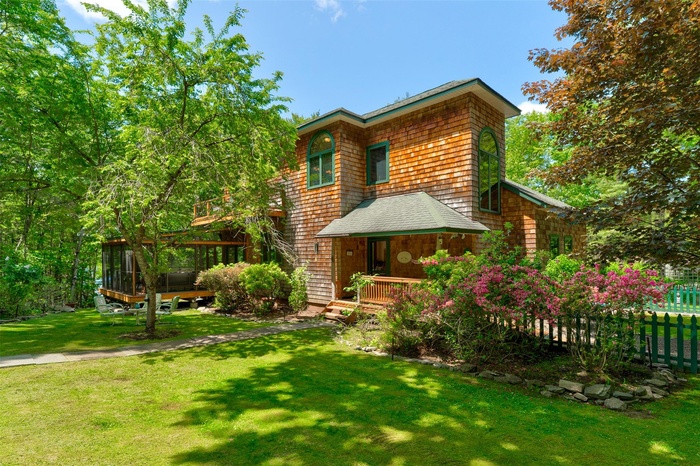 View of front of home featuring a sunroom and a deck