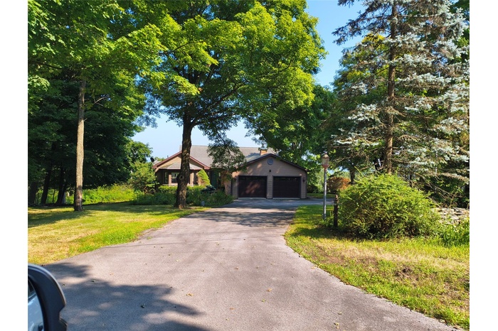 View of front of home with driveway, a front yard, and an attached garage