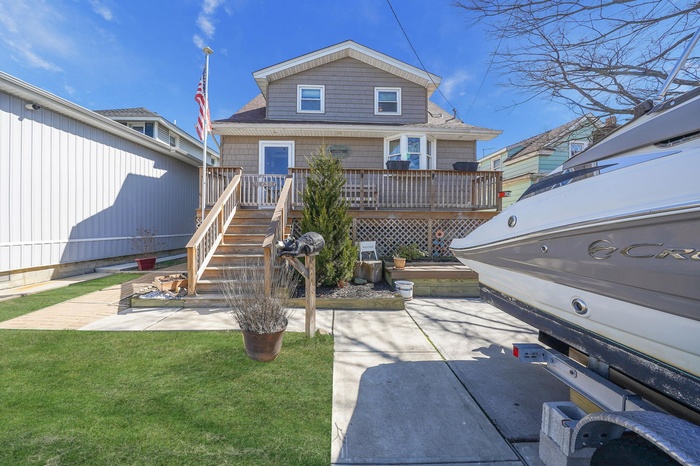 Back of house featuring a patio area, a deck, stairway, and a lawn