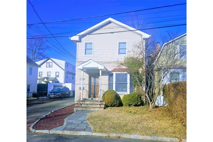 Traditional-style home featuring brick siding and fence