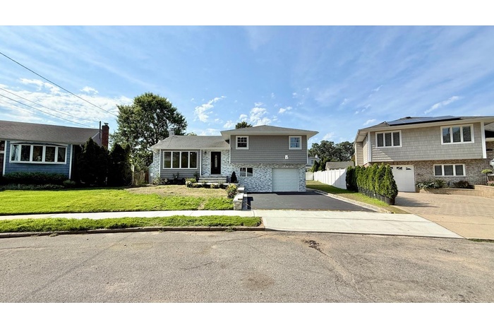 Split level home featuring an attached garage and driveway