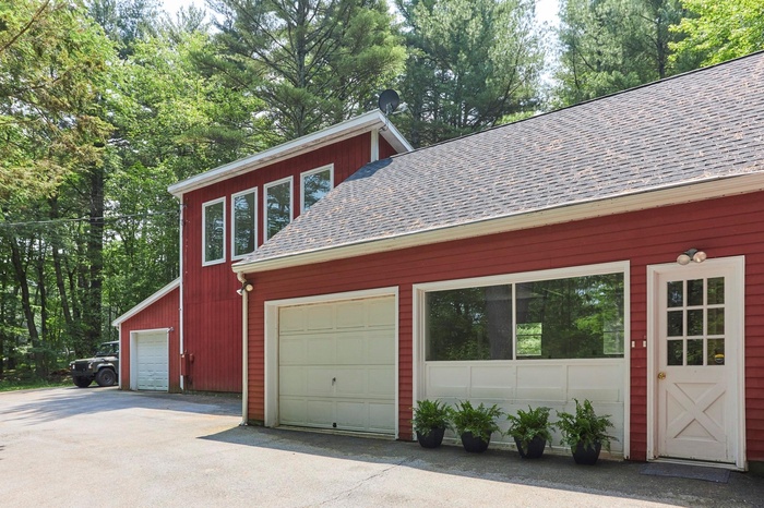 View of side of home with a shingled roof