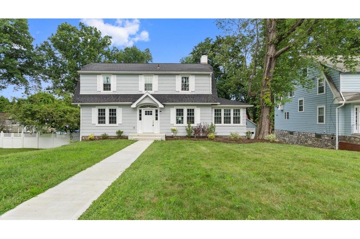 Dutch colonial featuring a chimney and a shingled roof