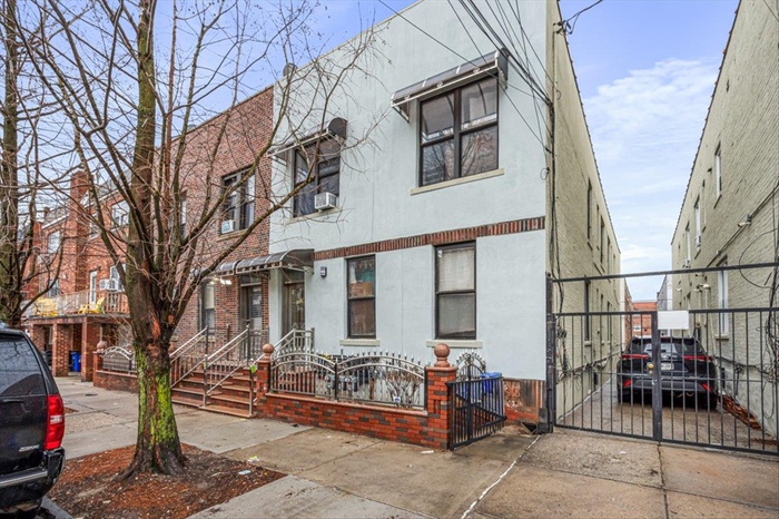 Townhome / multi-family property with stucco siding, driveway, a gate, a fenced front yard, and cooling unit