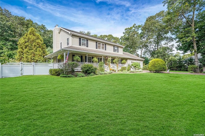 Country-style home featuring a chimney and covered porch