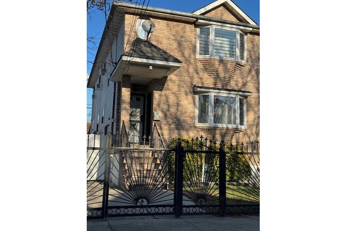 View of front of home featuring brick siding, a gate, and a fenced front yard