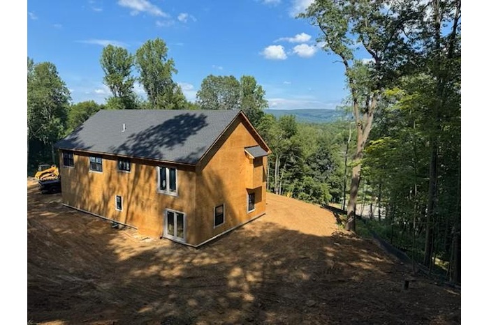 View of home's exterior featuring a shingled roof and stucco siding