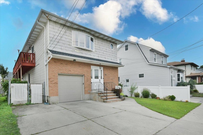 View of front of house featuring concrete driveway, brick siding, and a garage