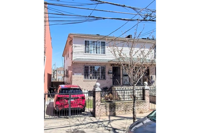 Traditional-style house featuring a fenced front yard, brick siding, and a gate