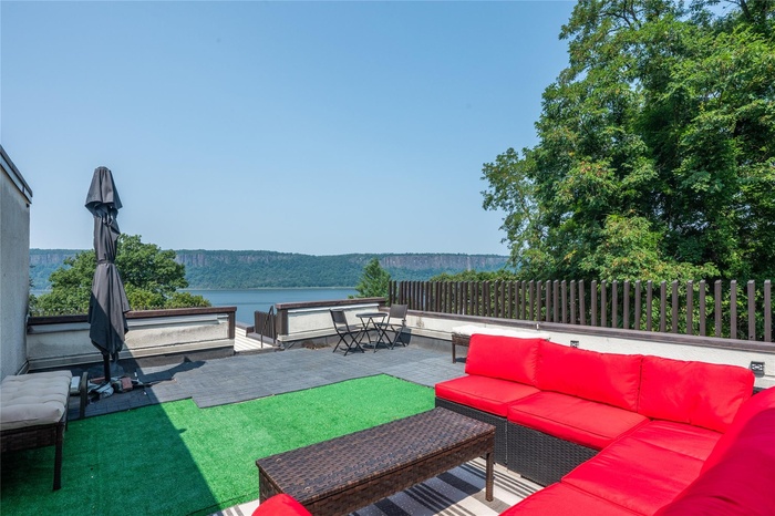 View of patio with outdoor lounge area and a water view