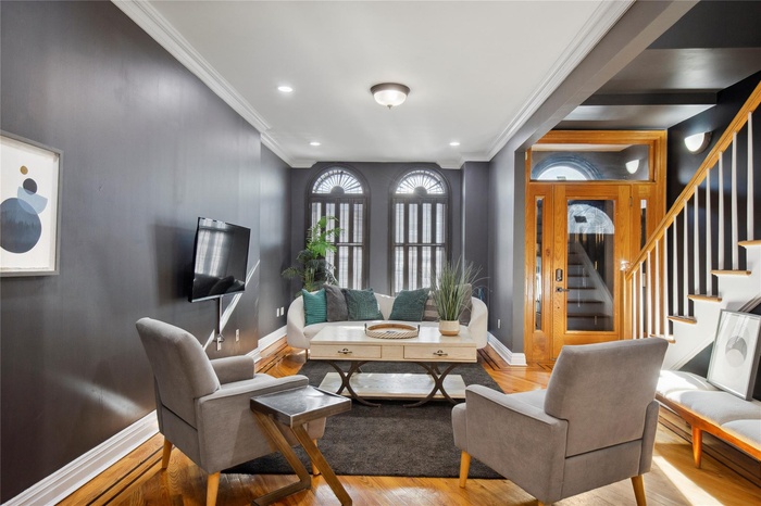 Sitting room featuring crown molding, stairway, wood finished floors, and recessed lighting