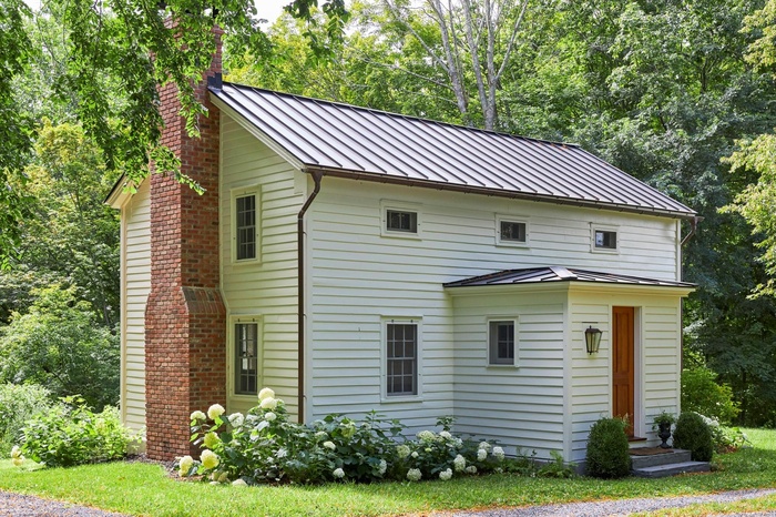 Featuring a standing seam roof, a metal roof, and a chimney