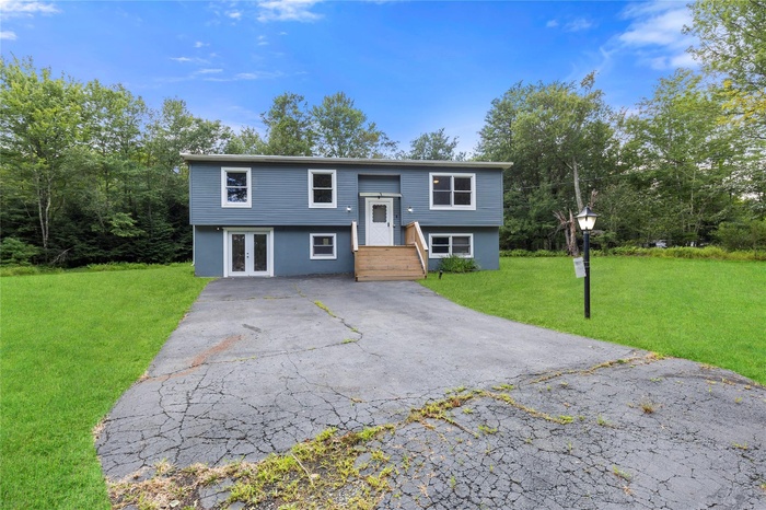 Split foyer home featuring french doors, driveway, and a front lawn