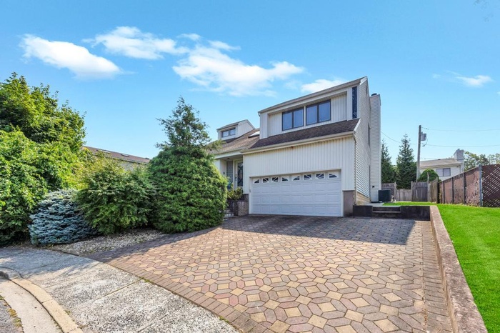 View of front of home featuring decorative driveway and an attached garage