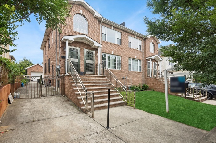 Multi unit property featuring an outbuilding, brick siding, and a garage