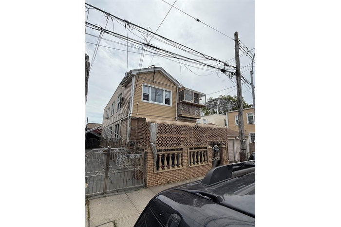View of front of house featuring a gate and brick siding