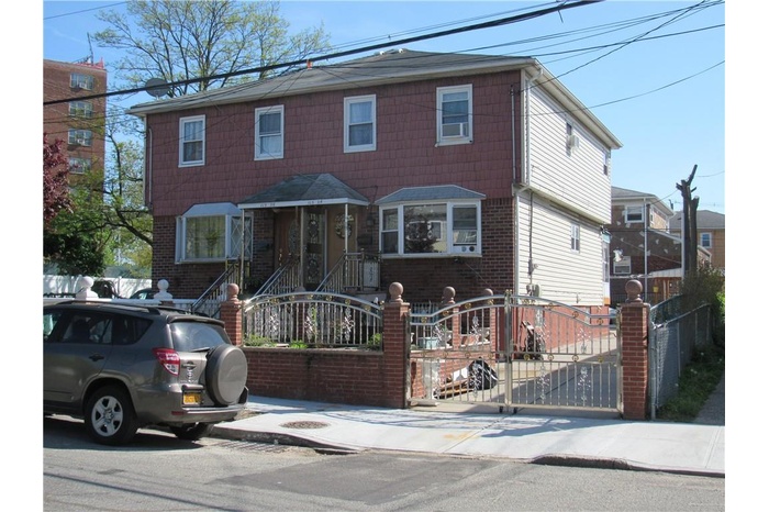 View of front of property featuring a fenced front yard, brick siding, and a gate
