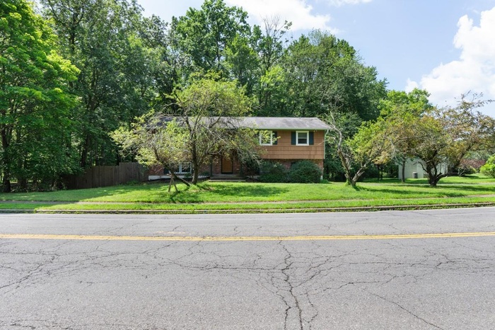 View of front of home with brick siding and view of scattered trees