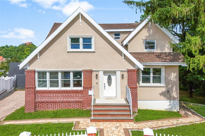 Tudor home featuring stucco siding and roof with shingles