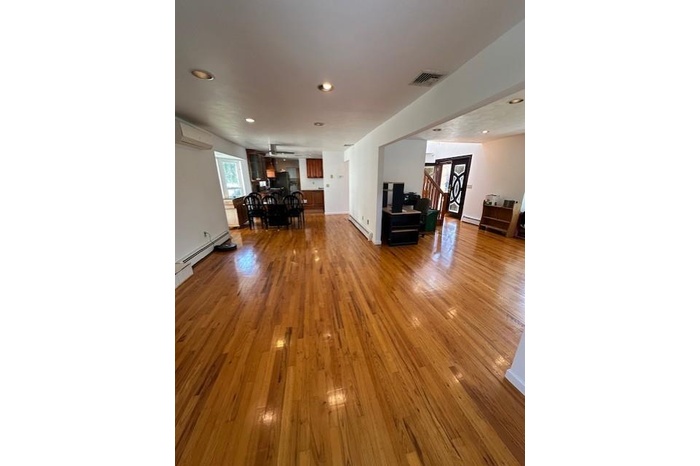 Living area featuring hardwood / wood-style flooring, healthy amount of natural light, recessed lighting, a baseboard heating unit, and a baseboard ra