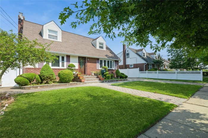 Cape cod house with brick siding and a chimney