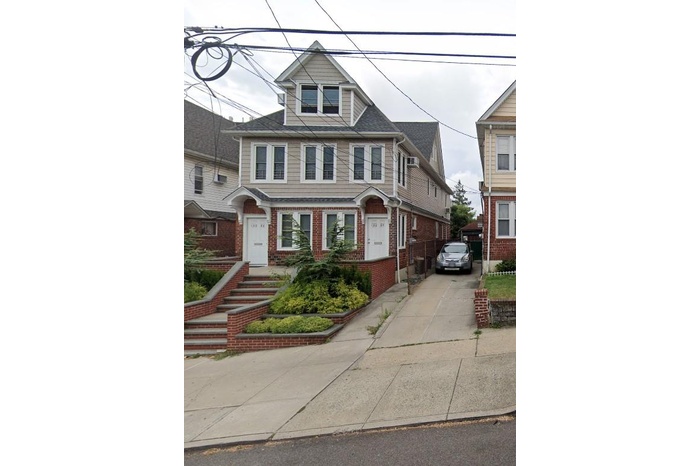 American foursquare style home featuring brick siding