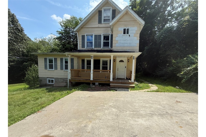 View of front of house featuring a porch and a front yard